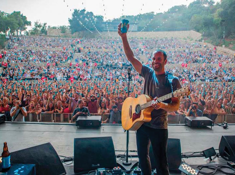 Photo of Jack Johnson on stage with crowd in background